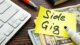 Banner image for the post, "25 Side Gigs You Can Start In 2023 Without Breaking the Bank" featuring a Post-It Note that reads "Side Gig".