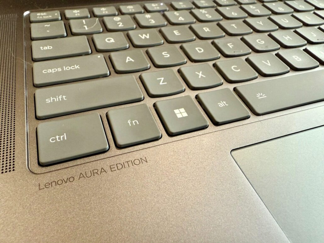 Close-up of the Lenovo Yoga Slim 7i Aura Edition keyboard, highlighting the keys and engraved “Lenovo Aura Edition” branding.