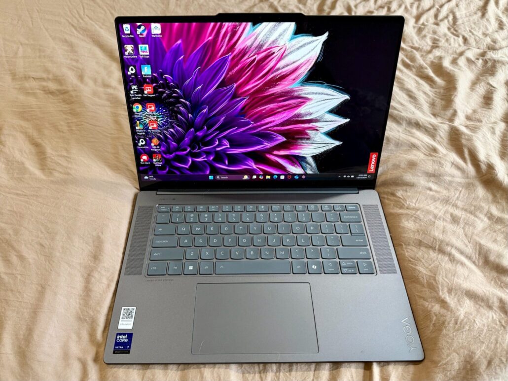 Lenovo Yoga Slim 7i Aura Edition laptop open with display on, showing a vibrant purple flower wallpaper.