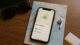 iPhone showing Find My app tracking Tony’s AirPods on a paper map with travel accessories on a wooden table