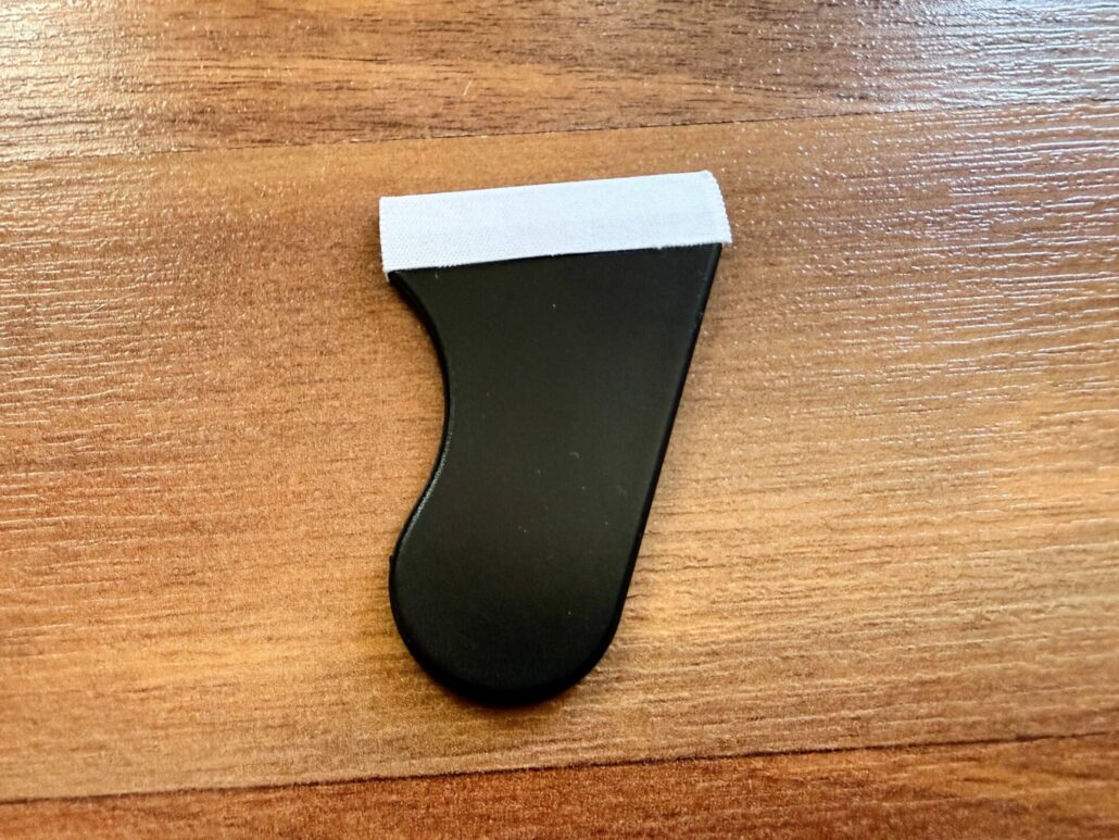 Small black squeegee tool with a fabric edge included in the amFilm kit for removing air bubbles during installation.