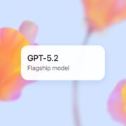 OpenAI officially designates GPT-5.2 as its new “Flagship model” starting December 11. A promotional graphic for the OpenAI GPT-5.2 release, featuring a white badge that reads "GPT-5.2 Flagship model" against a soft, blurred floral background.