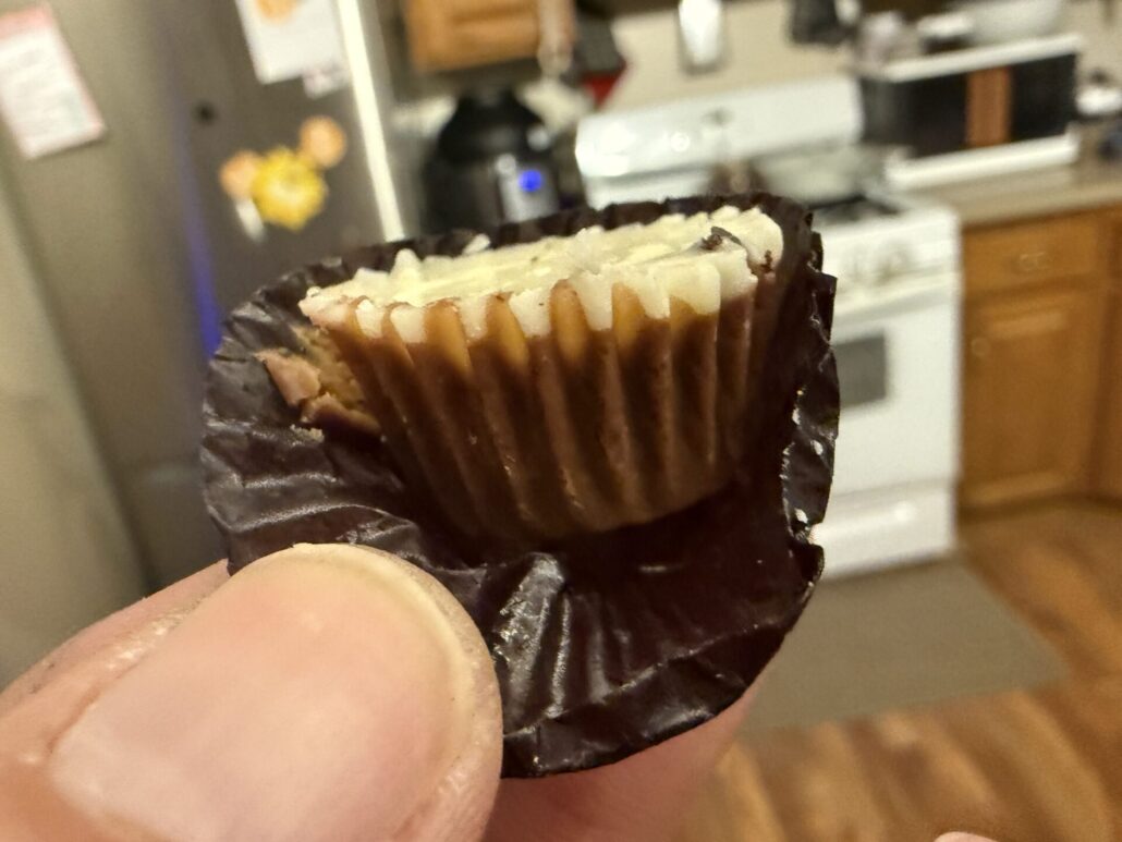 Bitten Reese’s Oreo Miniature Cup showing peanut butter filling and cookie pieces