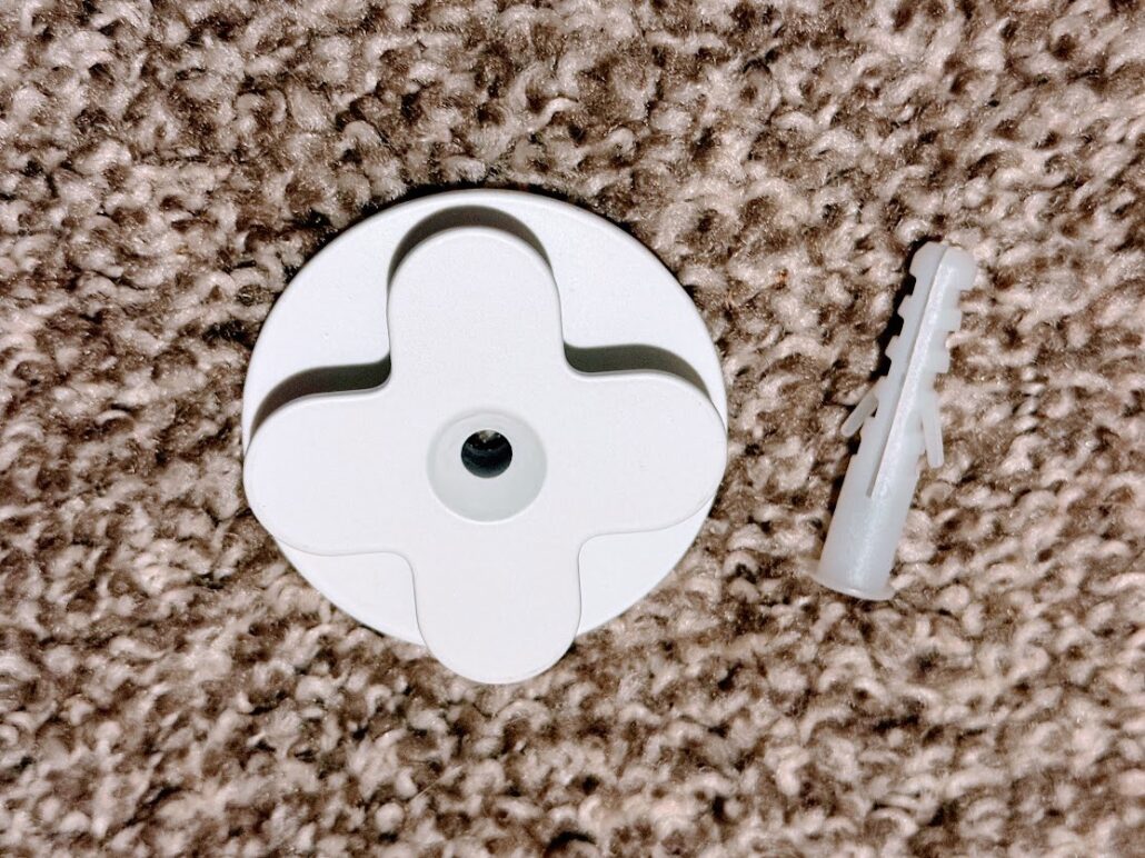 LIFX Luna wall mount bracket and drywall anchor resting on a carpet