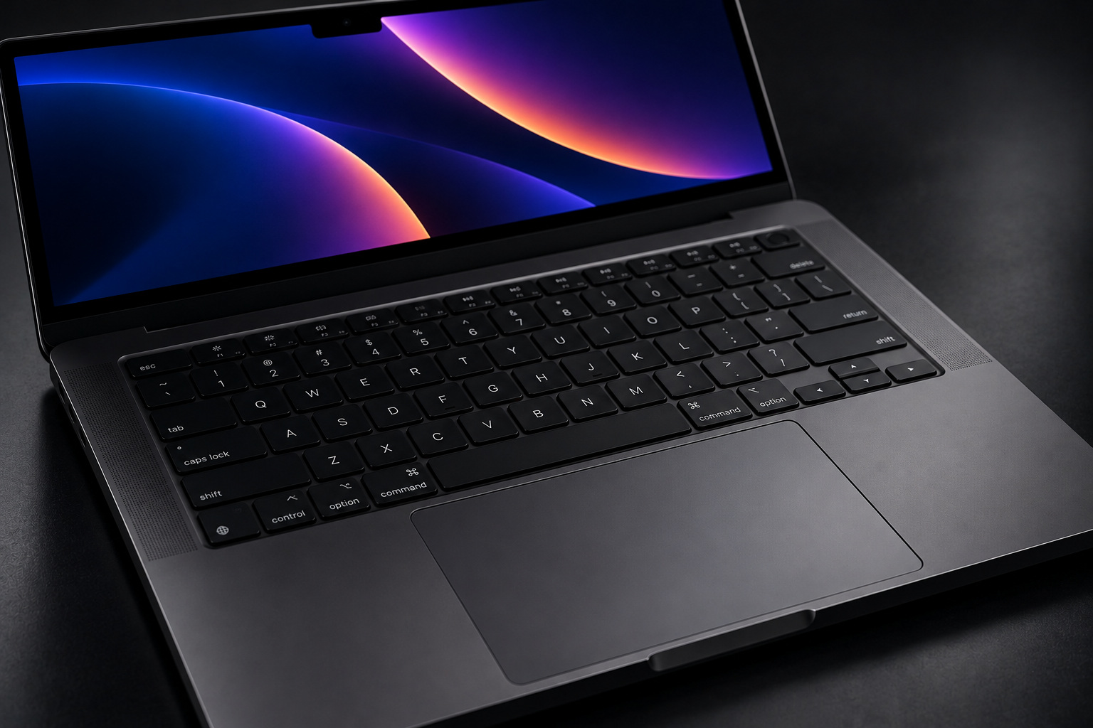 Angled close-up rendering of a Space Black MacBook Pro keyboard, speaker grilles and large trackpad under subdued studio lighting